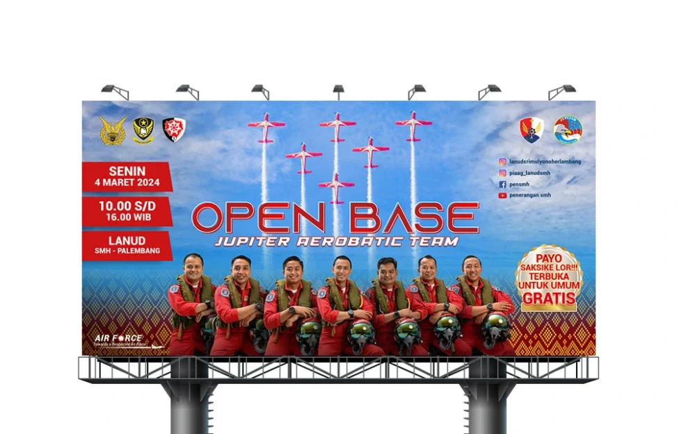 Desain baliho Open Base Jupiter Aerobatic Team di Palembang, menampilkan visual aksi pesawat aerobatik dan foto tim pilot dengan informasi lokasi serta jadwal acara.
